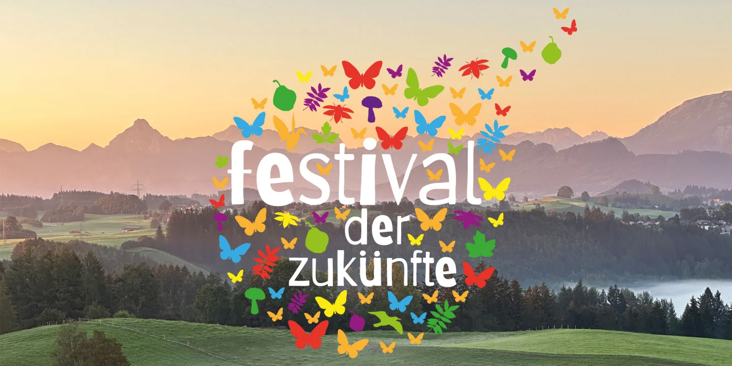 Logo des Festival der Zukünfte vor Bergpanorama mit Sonnenuntergang