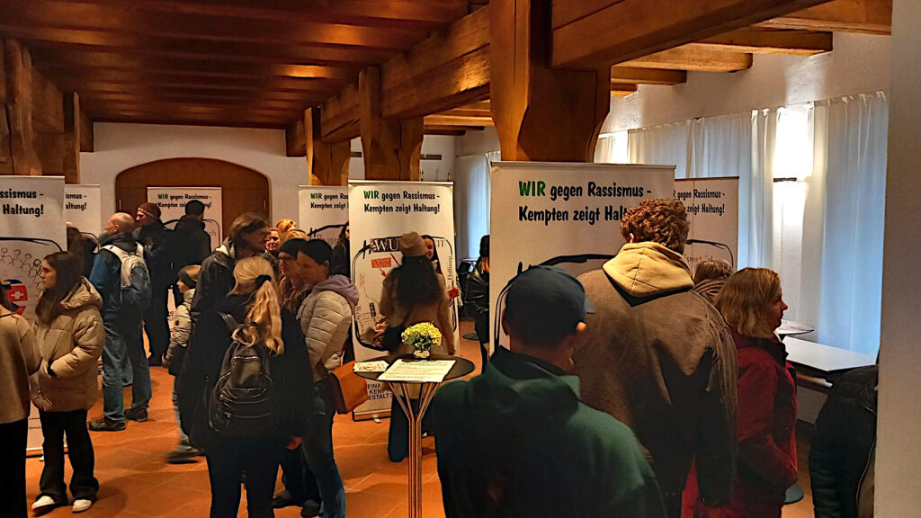Zahlreiche Menschen schauen sich in der Schrannenhalle des Rathauses die Ausstellung an.