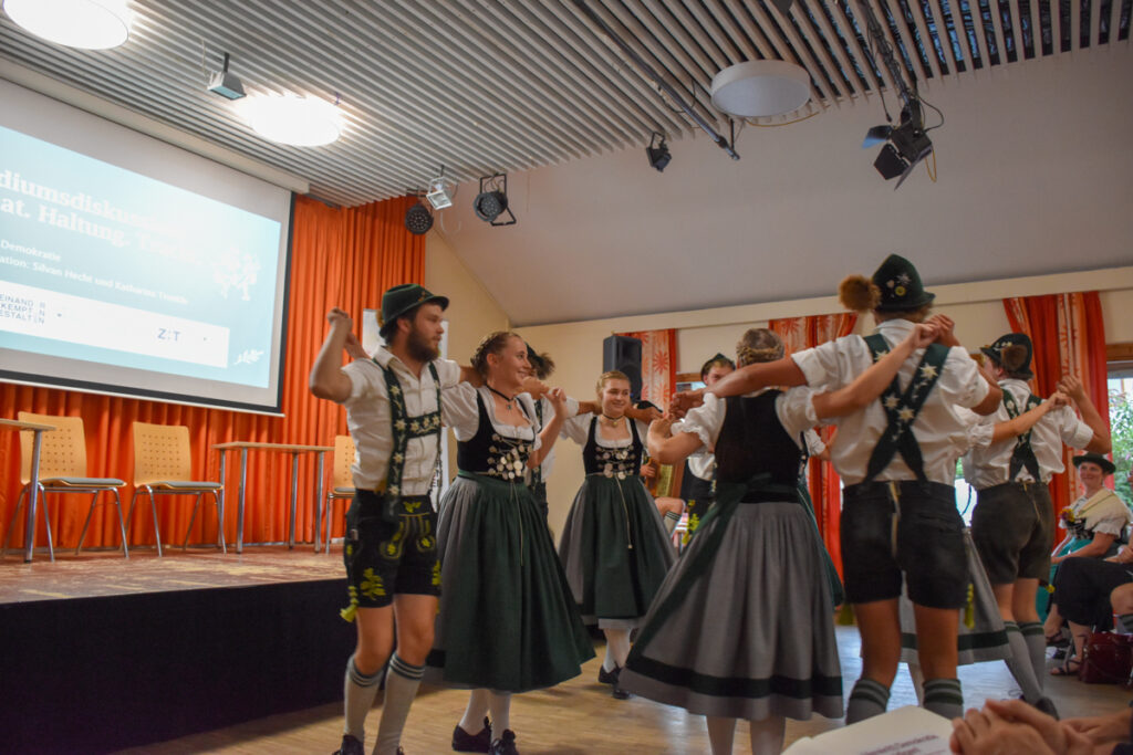 Mitglieder des Burgberger Trachtenvereins tanzen in traditioneller Tracht beim Schuhplattler-Auftritt zum Auftakt der Podiumsdiskussion „Heimat. Haltung. Tracht.“ im Haus International in Kempten.